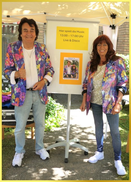 Schatzi und die Schlagerpiratin stehen vor einem Plakat.
