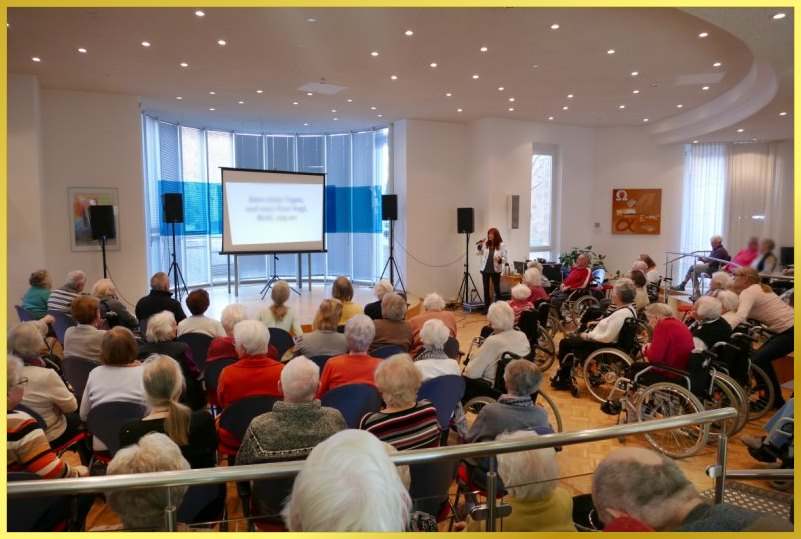 Runder Saal mit B�hne. Schlagerpiratin singt. Texte auf der Leinwand zum mitlesen.