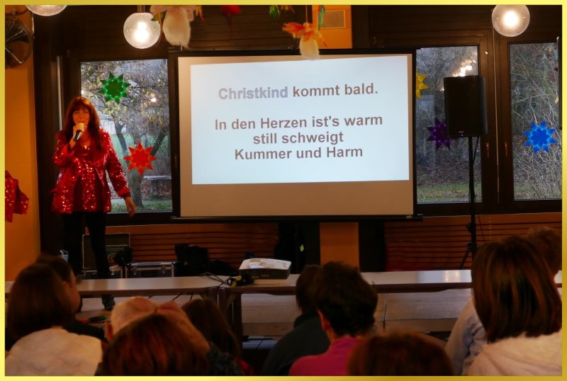 Schlagerpiratin neben der Leinwand beim Weihnachtsmitsingkonzert.