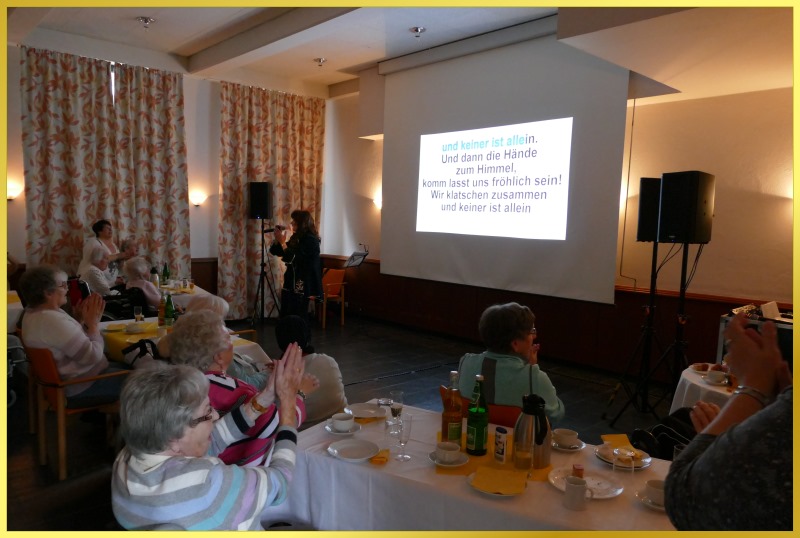 Die Schlagerpiratin steht beim Mitsingkonzert neben der Leinwand.