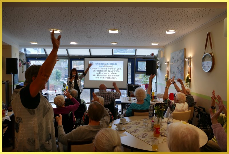 Die Schlagerpiratin neben einer Leinwand, wo die Liedtexte mitzulesen sind.