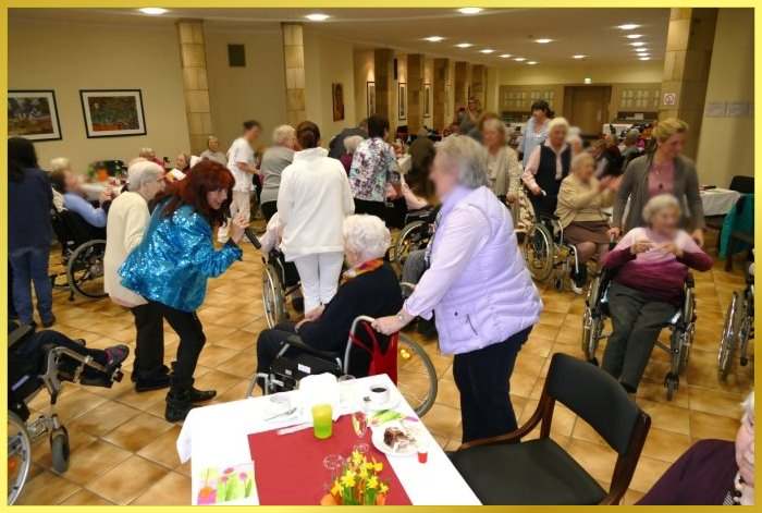 Gro�er Saal mit Rollstuhlpolonaise. Schlagers�ngerin animiert.