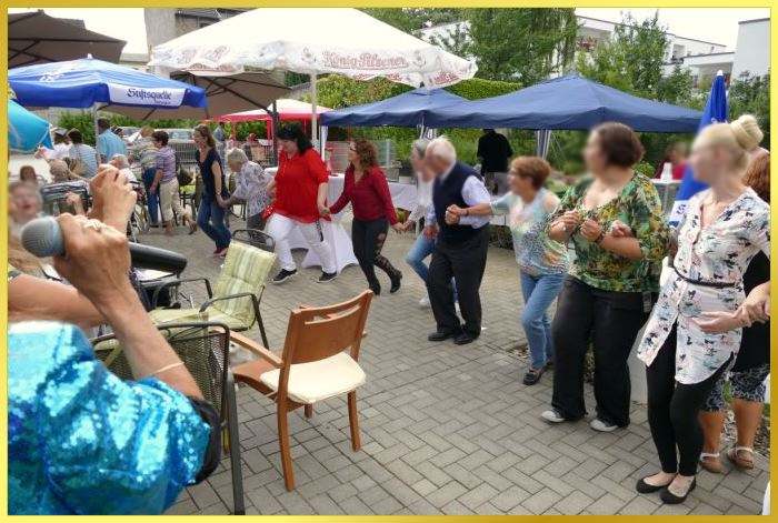 Marina singt open Air, Publikum h�lt sich in einer Reihe an den H�nden und tanzt.