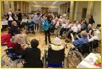 Schlagers�ngerin Marina umringt von Rollstuhlfahrern singt und animiert zum mitklatschen.