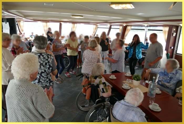 Publikum auf dem Rheinschiff tanzt. Schlagersngerin Marina singt.