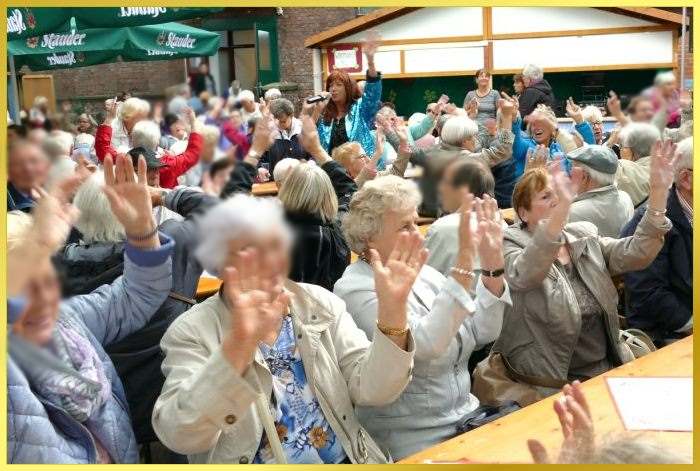 Vollbesetzte Gartenb�nke beim Sommerfest. Marina singt.