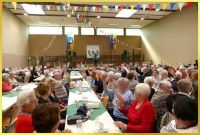 Gro�er Saal mit sitzenden Senioren. Schlagers�ngerin Marina auf der B�hne.