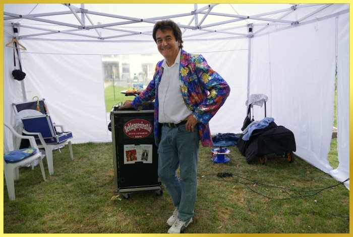 Ian steht vor der Technik im kleinen Zelt auf der Wiese