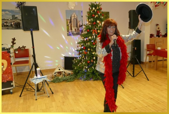 Weihnachtsfeier mit Schlagerpiratin. Steht vor dem Weihnachtsbaum und singt!