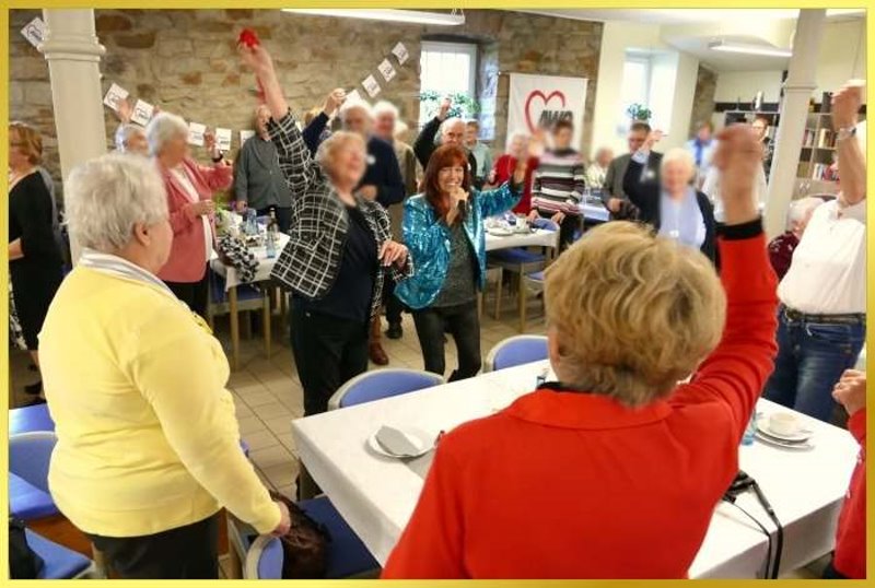 Saal voll lachender Leute. Schlagerpiratin singt das Cowboy und Indianer Lied.