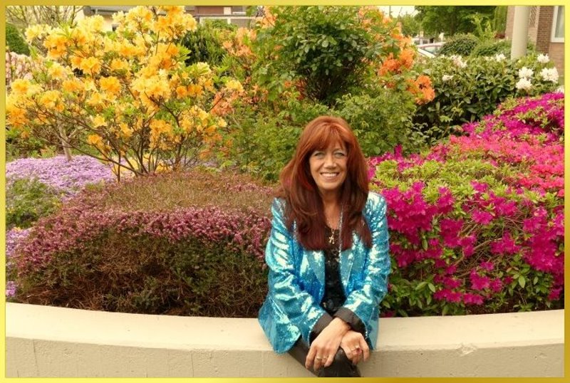 Schlagerpiratin sitz vor Blumenbeet.