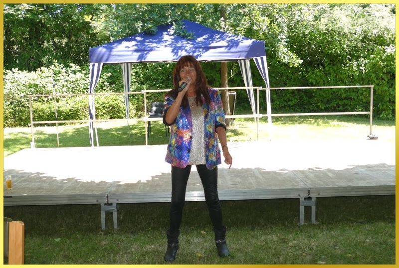 Schlagerpiratin steht vor der Open Air B�hne und singt.