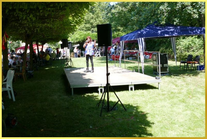 Die Schlagerpiratin auf der Open Air B�hne, umgeben von vielen B�umen.