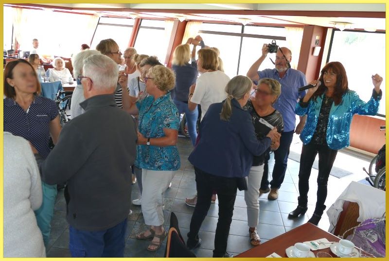 Marina singt zwischen tanzenden Leuten.