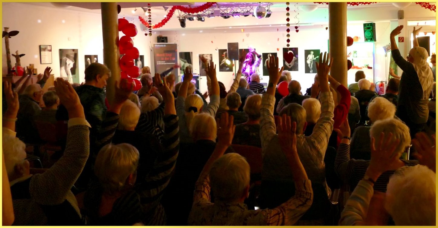 H�nde zum Himmel im vollbesetztem Saal. Schlagerpiratin singt.