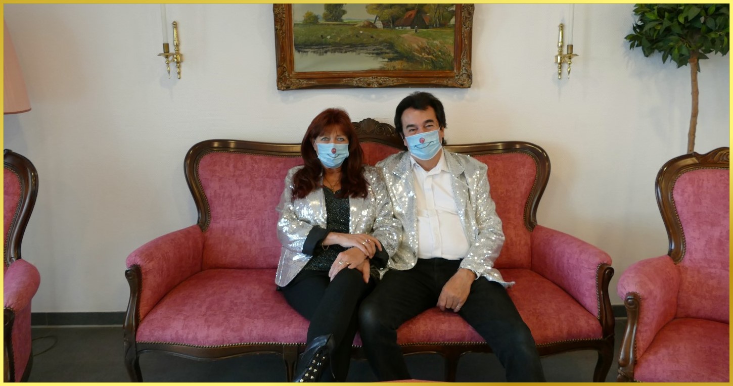 Schatzi & die Schlagerpiratin sitzen mit Mundschutz auf Oma's Couch.