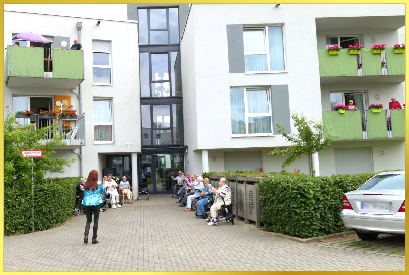 Schlagerpirain singt vor einem Geb�ude auf dem Parkplatz.
