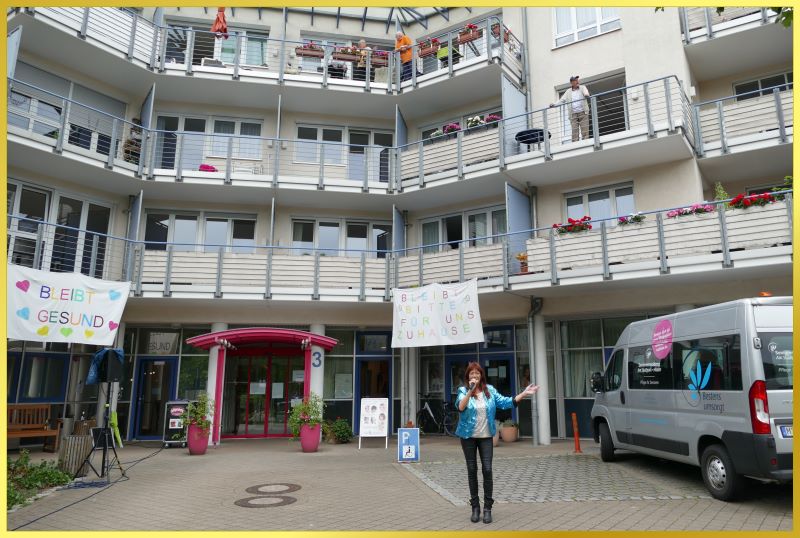 Schlagers�ngerin singt vor einem Geb�ude.