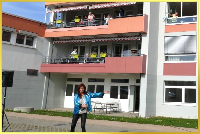 Die Schlagerpiratin schunkelt und animiert die Senioren auf den Balkonen, mitzumachen.