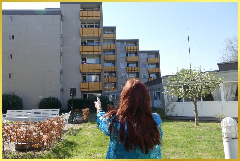 Schlagerpiratin steht vor Wohnblock und singt