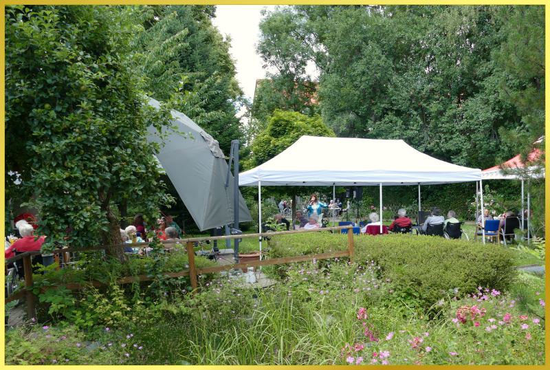 Schlagers�ngerin Marina steht in gro�er Gartenanlage und singt.