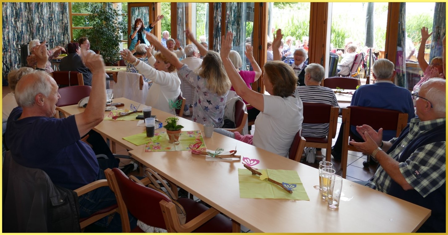 Viele feiernde Senioren im Saal und auf der Terrasse.