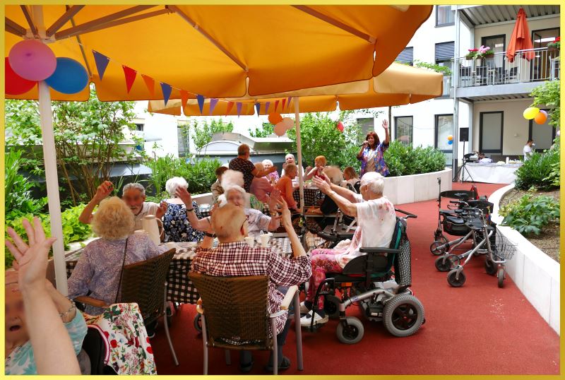 Bunte Luftballons und Girlanden an Sonnenschirmen.