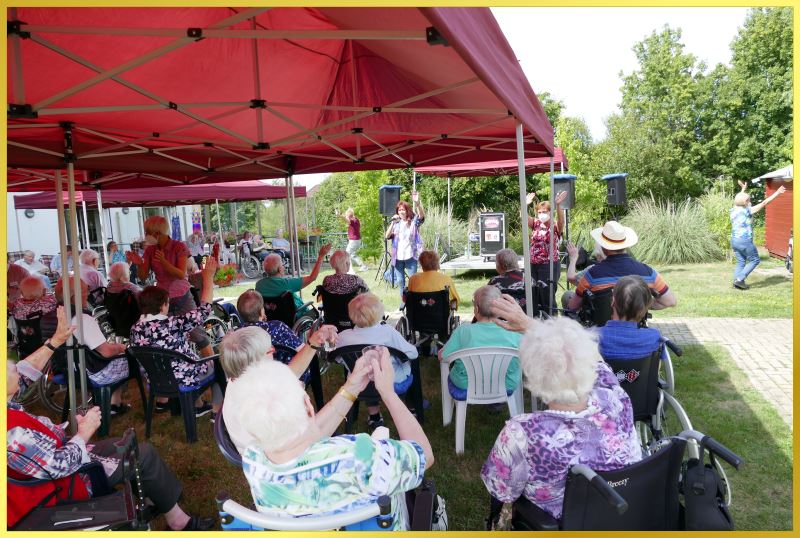 Publikum sitzt unterm Zelt, Schlagerpiratin singt.
