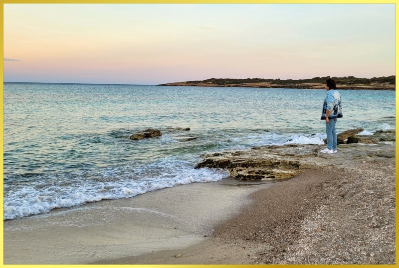 Ian steht am Ufer und guckt auf das Meer.