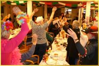 Feiernde stehen und winken beim Karnevalsauftritt.