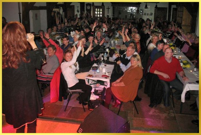 Gro�er vollbesetzter Saal mit langen Tischen. Schlagers�ngerin singt auf der B�hne!