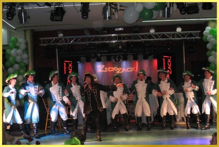 10 Karnevalsoffiziere schunkeln hinter singender Schlagerpiratin auf der gro�en B�hne.