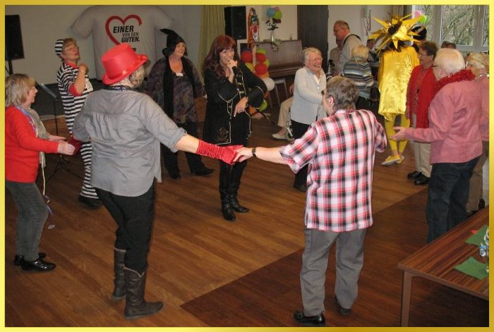 Schlagers�ngerin singt umringt von fr�hlichen G�sten, die tanzen und schunkeln.