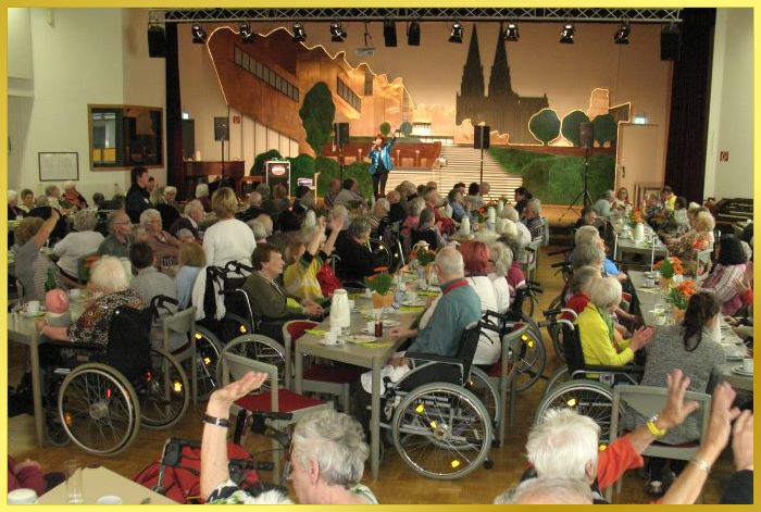 riesiger Saal, gro�e B�hne. Schlagerpiratin singt un animiert die G�ste. �berwiegend Senioren.