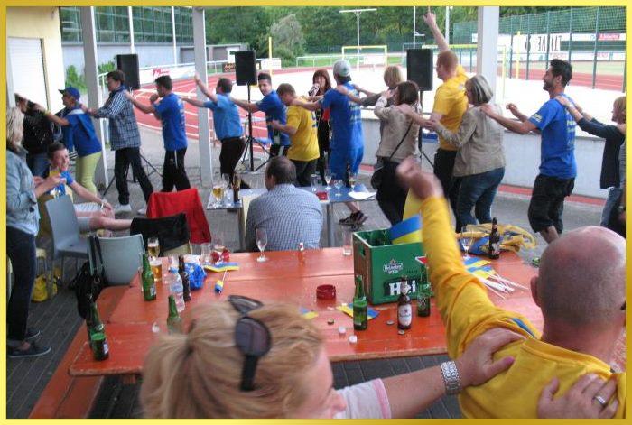 Party beim Fussballverein. Fussballer laufen bei dem Lied Atemlos im Kreis herum und singen laut mit