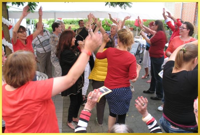 Schlagers�ngerin Marina singt. Um sie herum fr�hliche, tanzende G�ste.