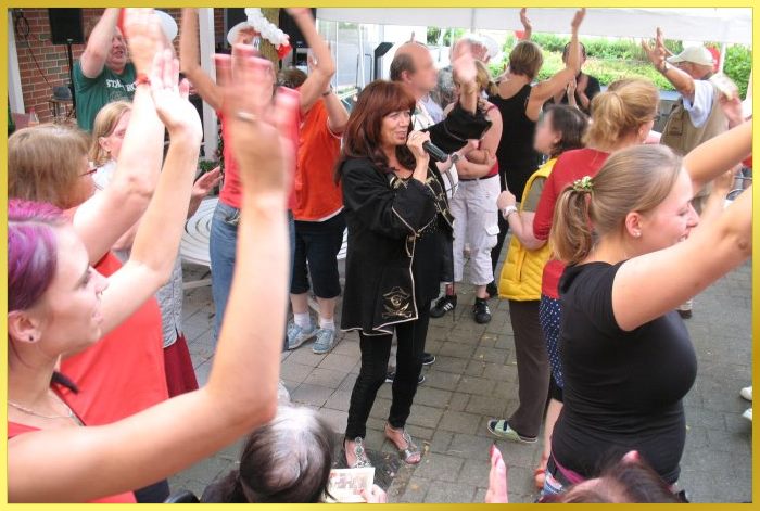 Alle H�nde oben. S�ngerin Marina singt mittendrin Schlagerhits.Altersgemischtes Pubklikum. Alle machen mit!