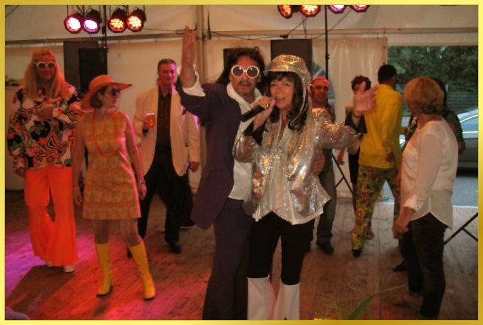 Festzelt mit verkleideten Partyg�sten. Alle im 70erJahre Look.Schlagers�ngerin singt.