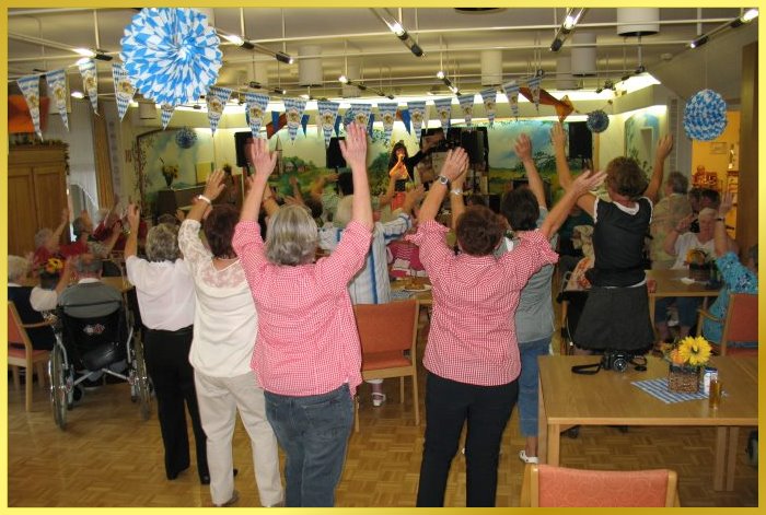 Gro�er Oktoberfest-Saal mit Leuten die stehen und winken. Blau wei� geschm�ckt. Schlagers�ngerin auf der B�hne.