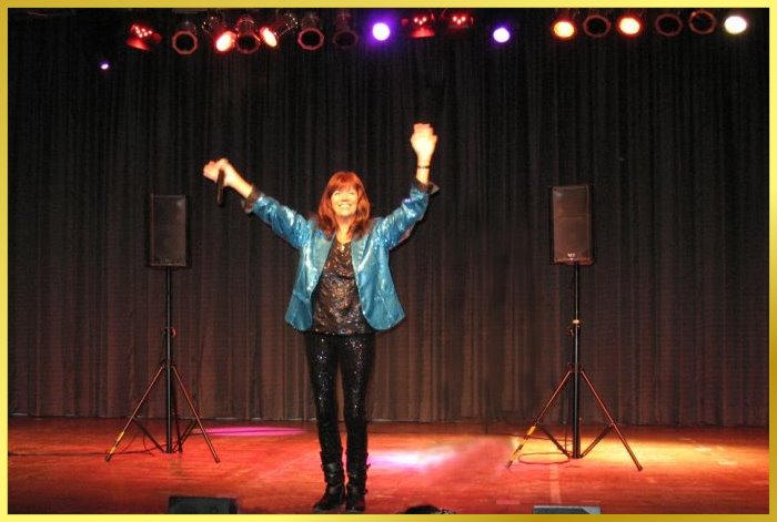 Schlagers�ngerin strahlt und winkt auf breiter buntbeleuchteter Rathaussaal-B�hne.