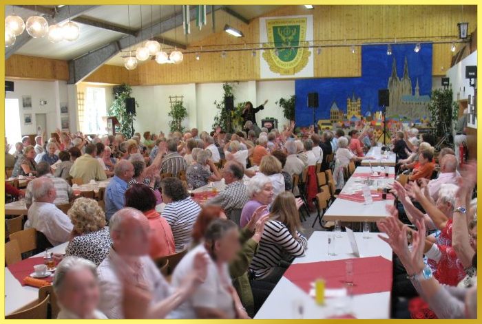 Vollbesetzter gro�er Saal mit Senioren. Schlagerpiratin auf der B�hne singt.