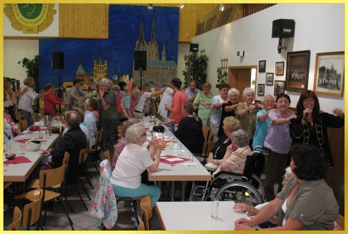 Menschenschlange hinter der Schlagers�ngerin, die lachend singt und anf�hrt.