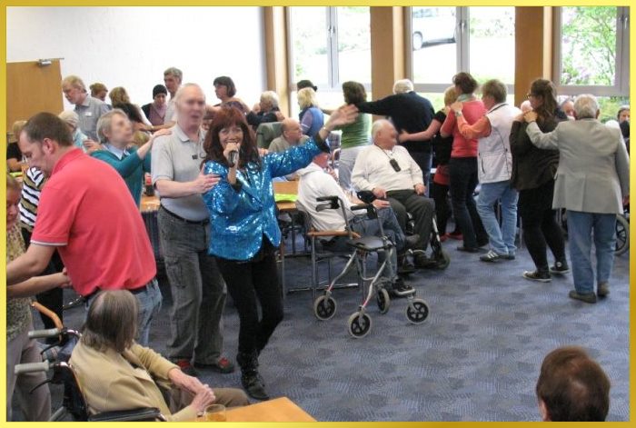 Marina, mit t�rkieser Paillettenjacke, f�hrt die lange Menschenschlange an.