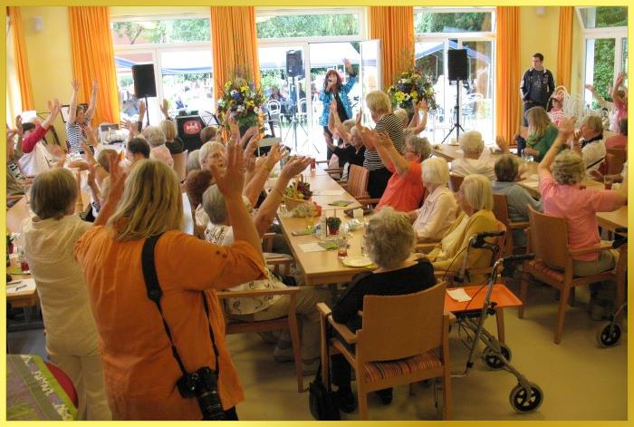 Voller Saal mit Menschen, die der S�ngerin zuh�ren und dabei im Takt winken.