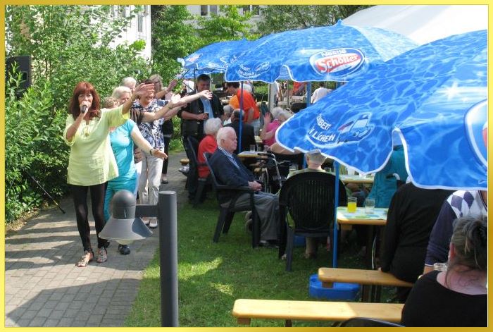 Marina mit gr�nem Oberteil u.schwarzen Glanzleggings singt und winkt.