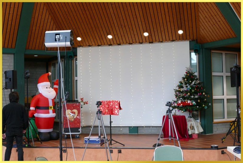 Aufblasbarer Weihnachtsmann, Tannenbaum und dekorierter Tisch auf der B�hne.