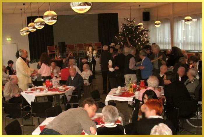 Schlagers�ngerin singt zur Weihnachtsfeier Schlageroldies. G�ste tanzen vor dem Weihnachtsbaum.