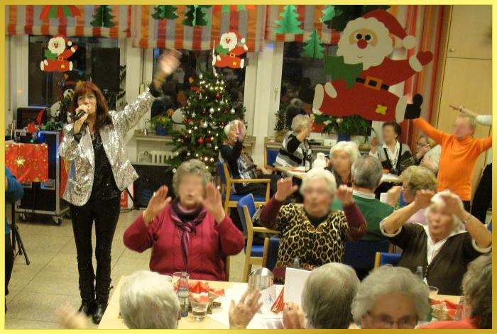 H�nde zum Himmel bei der Weihnachtsfeier. Schlagers�ngerin gibt ihr Bestes.